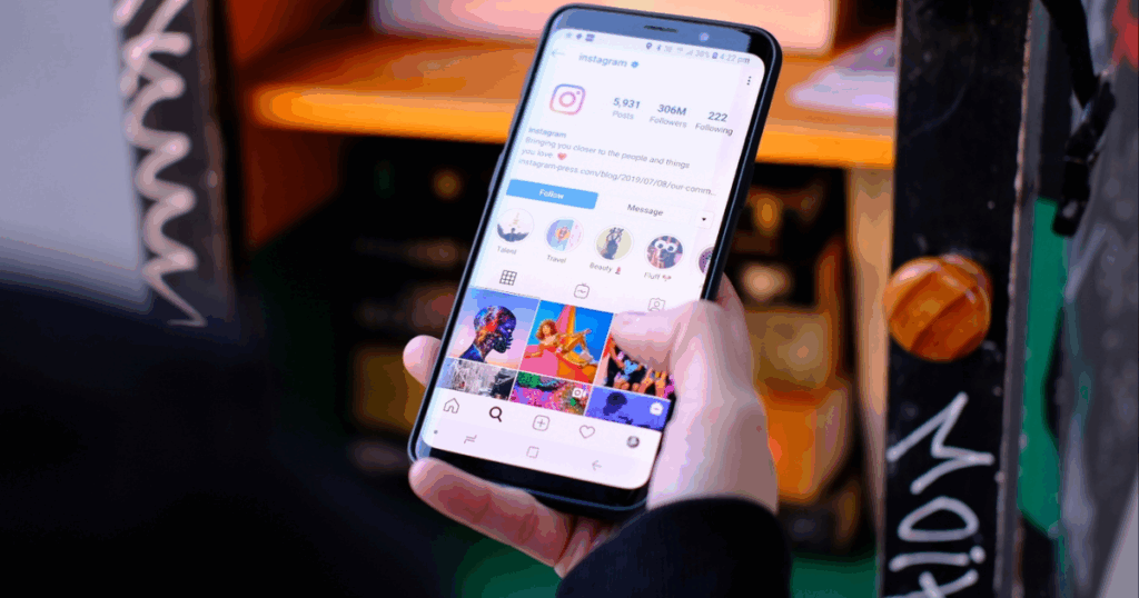Person browsing Facebook and Instagram feed on smartphone in a colorful urban setting