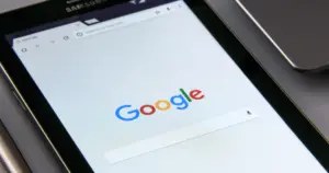 Close-up of a tablet screen displaying the Google homepage with focus on the search bar