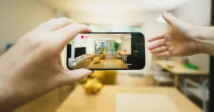 Person filming a bright modern space with a smartphone — representing ClickIt Digital’s professional video marketing and production services that help Las Vegas businesses boost visibility and brand engagement.