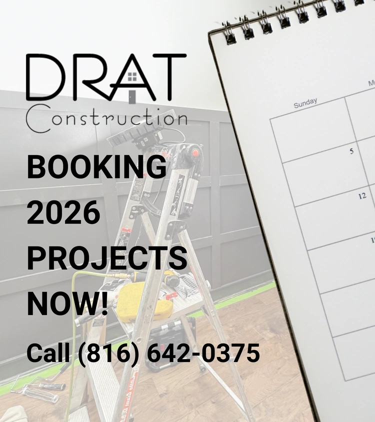 A construction calendar with the text “DRAT Construction. BOOKING 2026 PROJECTS NOW! Call (816) 642-0375” over an image of a step ladder and unfinished room.