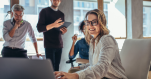 How much to spend on business marketing: small business owner planning a marketing budget with a calculator and laptop.